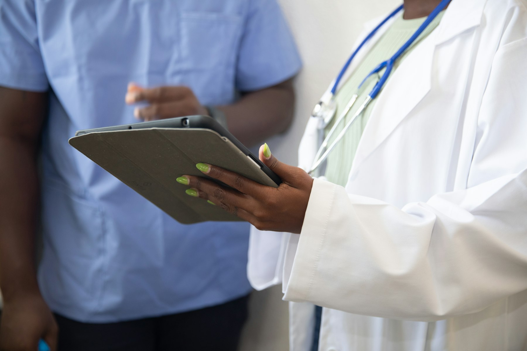 A clinician going through information with a patient on a tablet